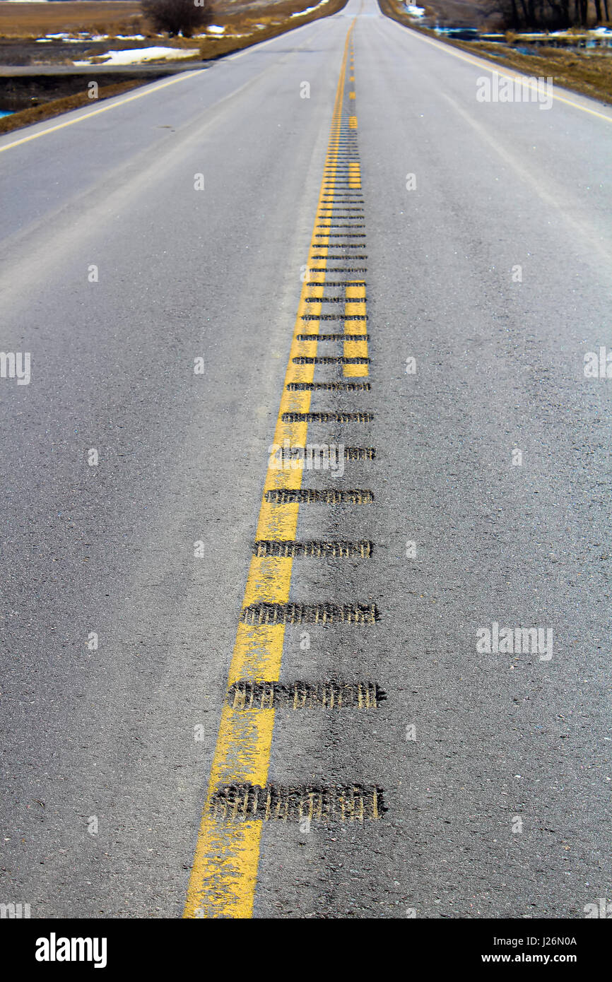 Center line rumble strips down a lonely country road. Stock Photo