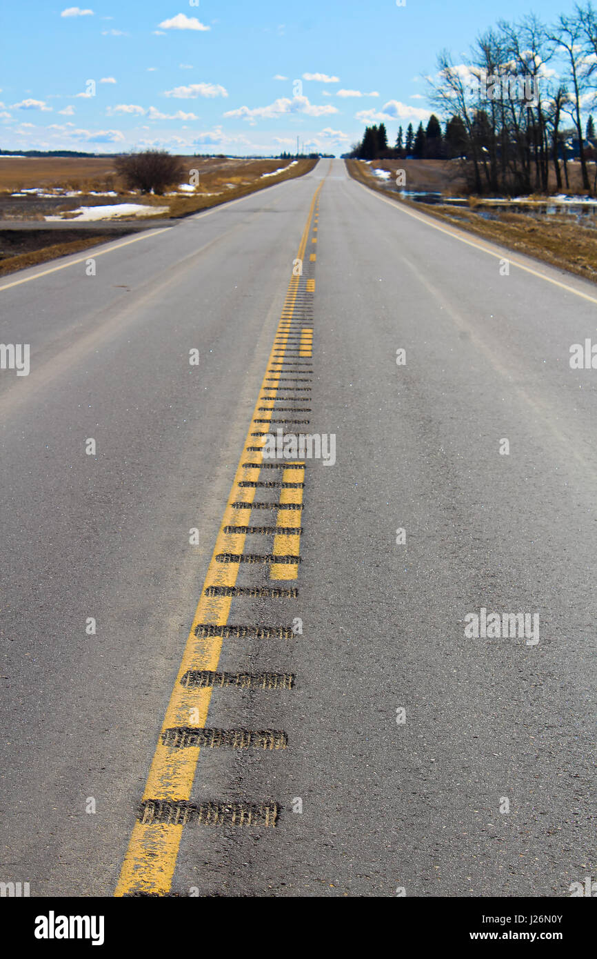 Rumble strips engraved into a secondary highway. Stock Photo