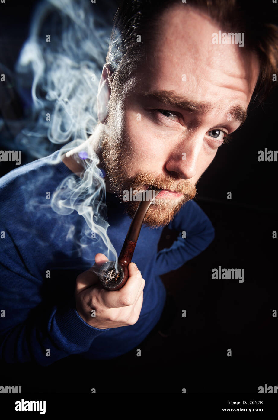 Funny handsome man smoking pipe. Toned photo, wide angle shoot. Stock Photo