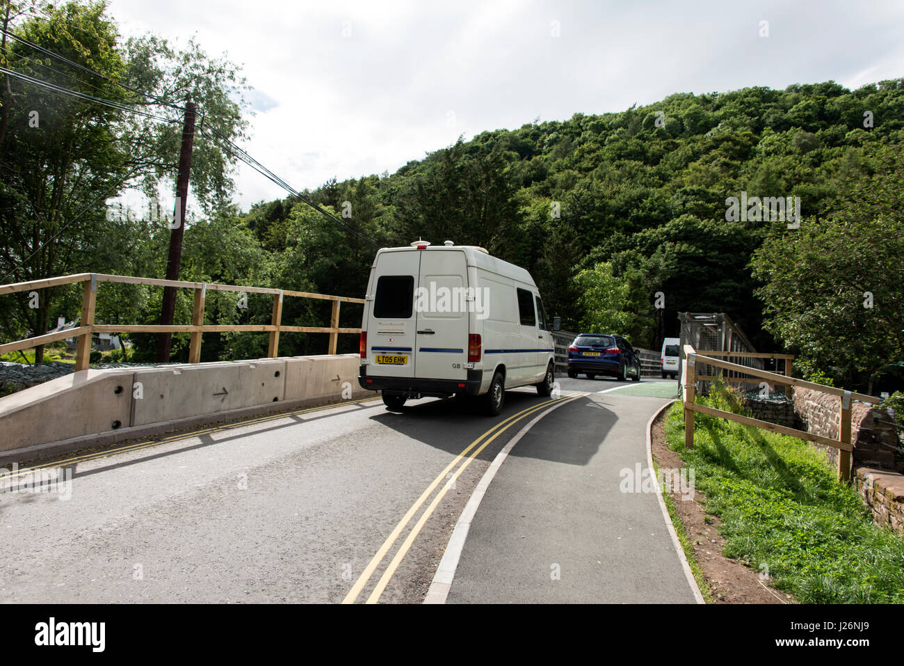Traffic crossing over a  temporary metal bridge with a green pedestrian walkway at Pooley Bridge, a village  named after the bridge across the River Stock Photo