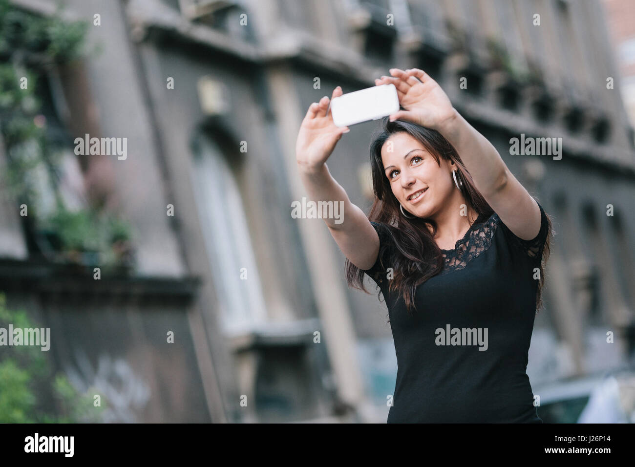 Happy beautiful young woman taking a selfie with her smart phone. Stock Photo