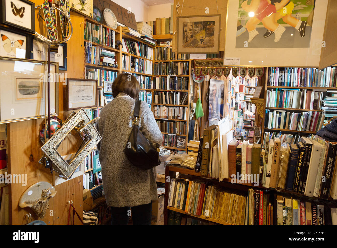 A woman buying books in a second hand bookshop, Lyme Regis Dorset UK Stock Photo