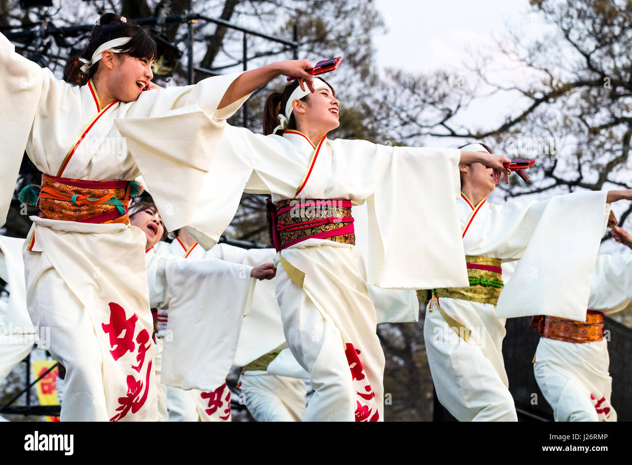 Hinokuni Yosakoi dance Festival at Kumamoto. Japanese women dancing on stage. Wearing white yukata with red sash, and holding naruko, clappers. Stock Photo