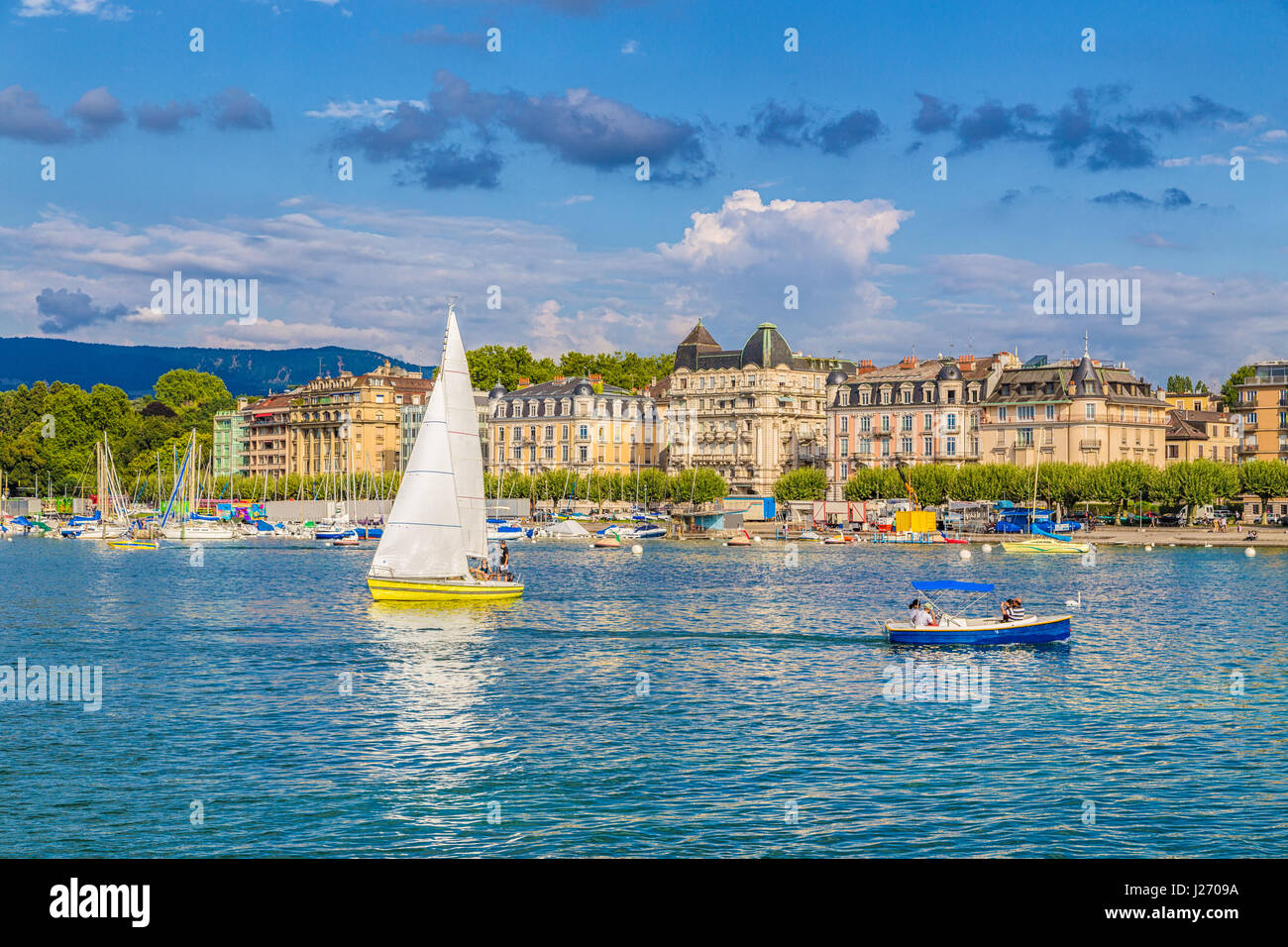 Beautiful view of the historic city center of Geneva with boats on Lake Geneva in the harbor in beautiful evening light at sunset, Switzerland Stock Photo