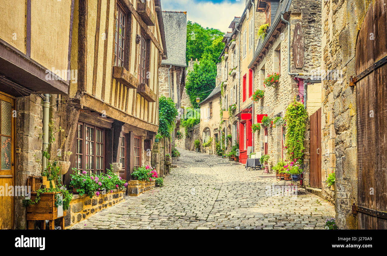 Beautiful view of scenic narrow alley with historic traditional houses and cobbled street in an old town in Europe with blue sky and clouds in summer  Stock Photo