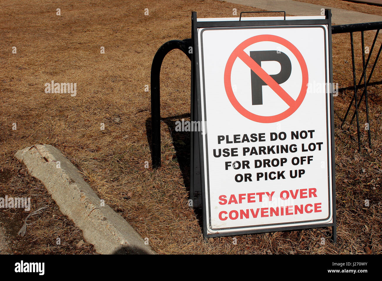 No Parking sign in a school staff lot beside some bike racks. Stock Photo