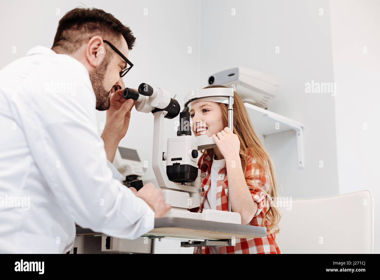 Dedicated ophthalmologist applying special equipment for diagnostics Stock Photo