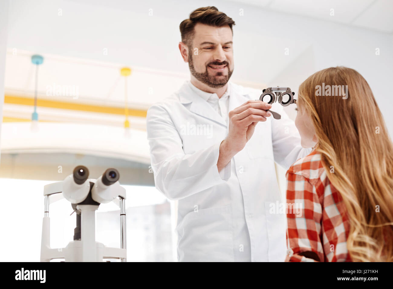 Qualified professional optician trying on special glasses Stock Photo