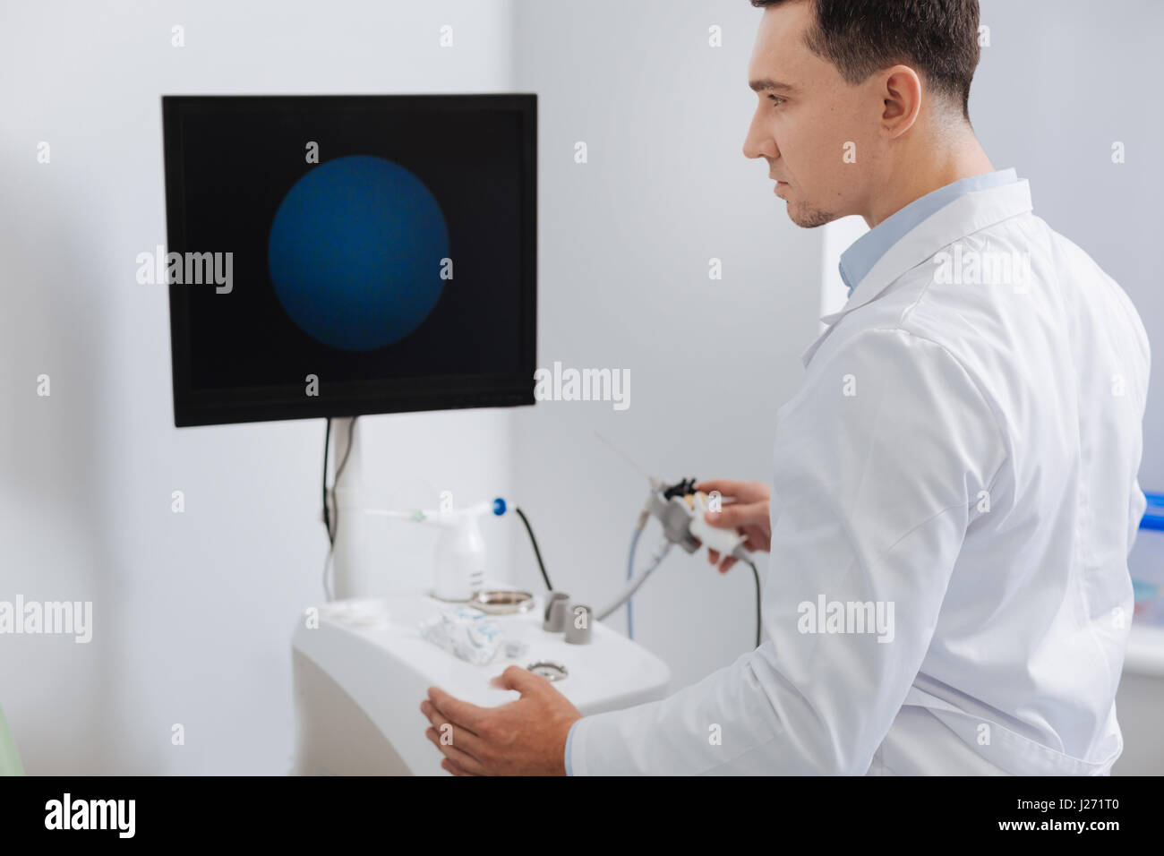 Young serious doctor working with special machine Stock Photo