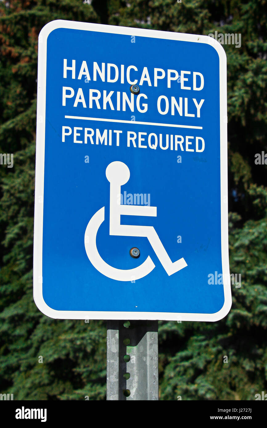 Handicap parking sign with trees in the background. Stock Photo
