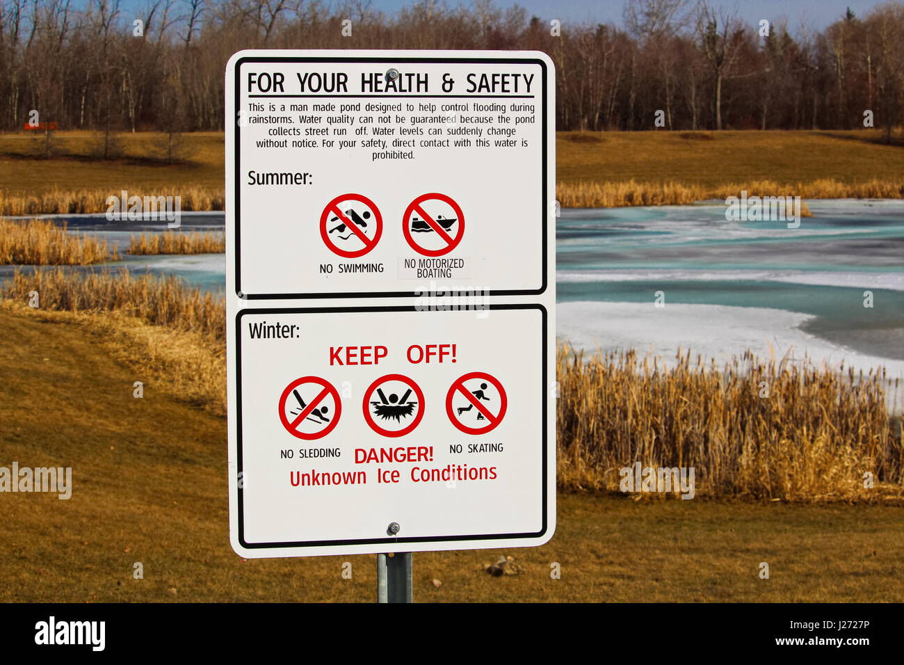 Warning signs around storm drainage pond Stock Photo Alamy