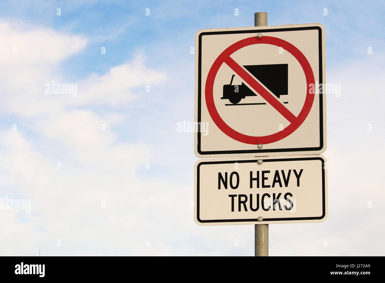 No Heavy Trucks Sign against Cloudy Blue Sky Background. Stock Photo