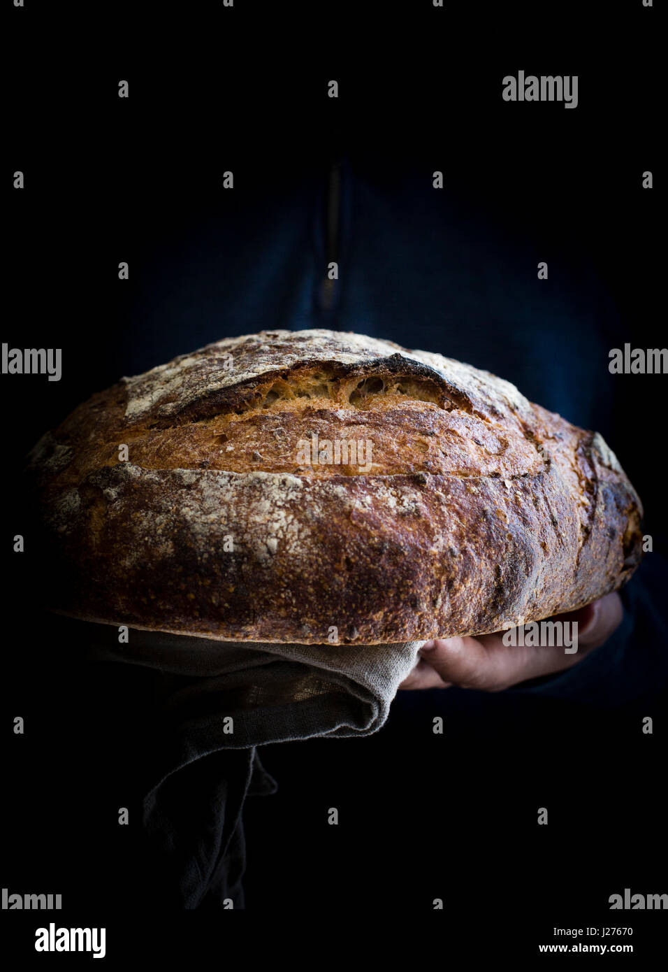 Man holding freshly baked sourdough bread front view Stock Photo