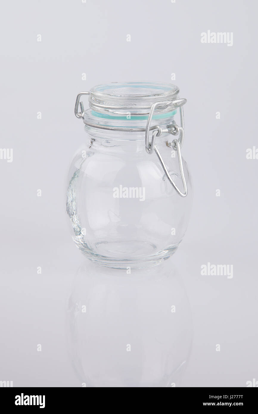 Empty clear glass jar on a white surface. Glass jar isolated on white background. Stock Photo