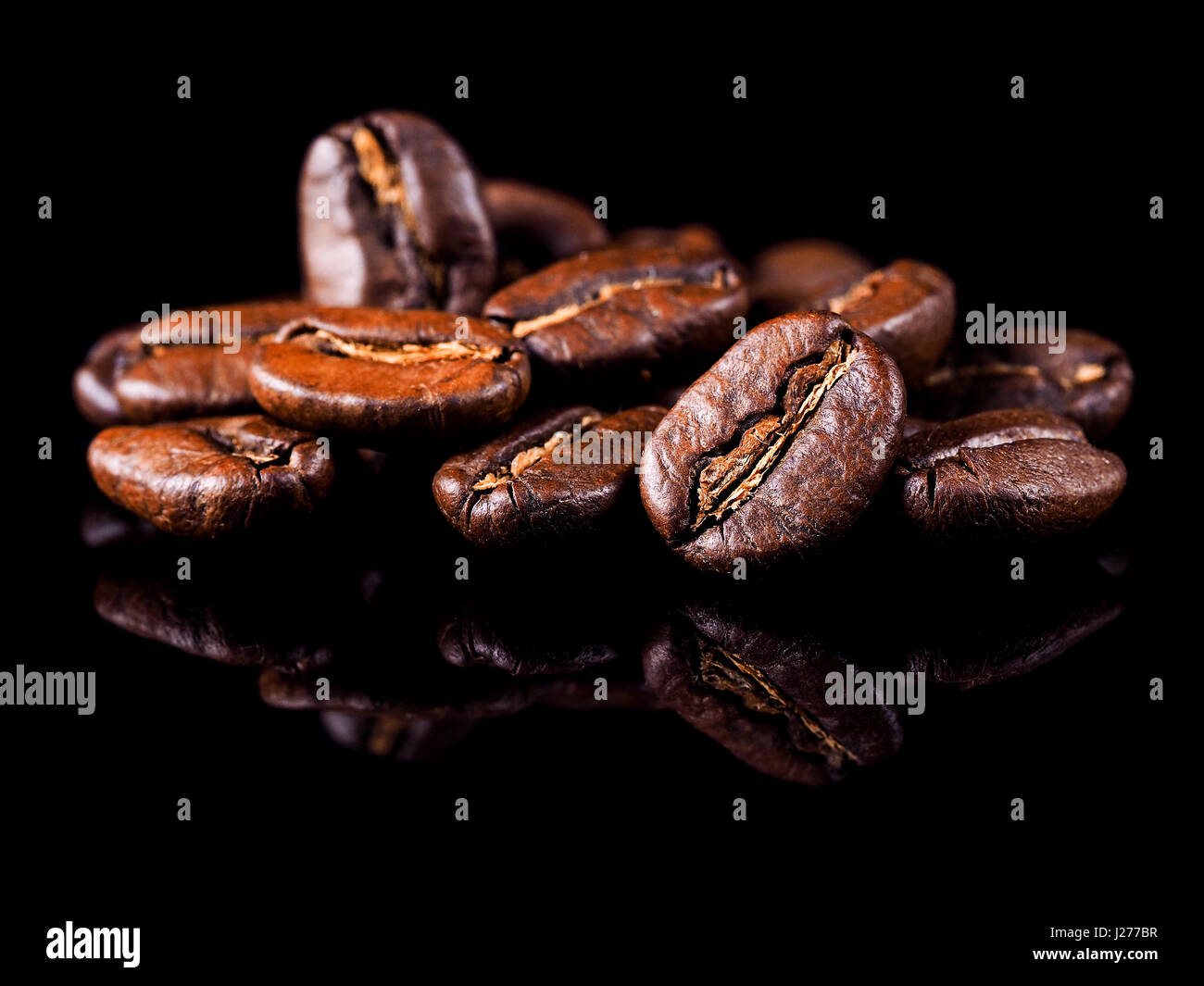 Roast coffee beans on the black background Stock Photo - Alamy