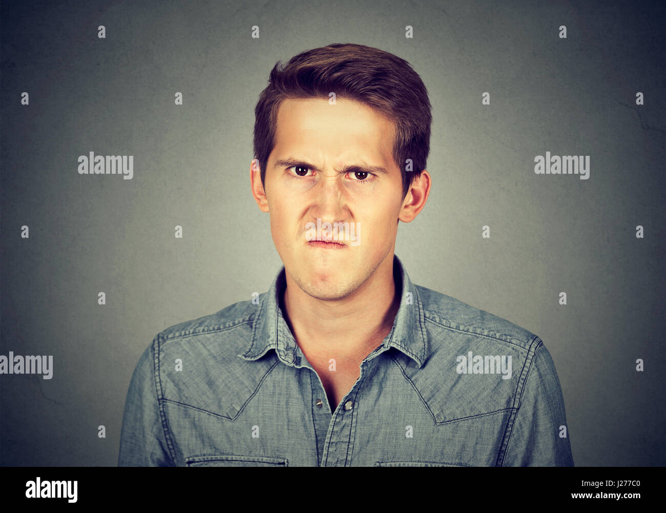 Angry young man, about to have nervous breakdown frustrated isolated on gray wall background. Negative human emotion facial expression feelings attitu Stock Photo