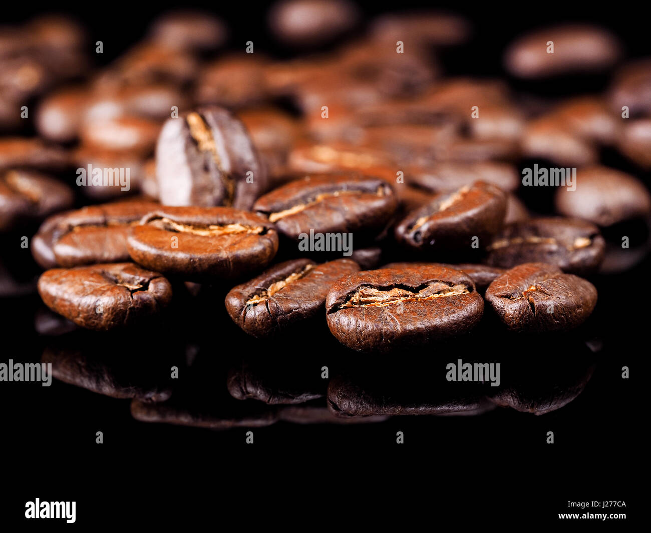 Roast coffee beans on the black background Stock Photo - Alamy