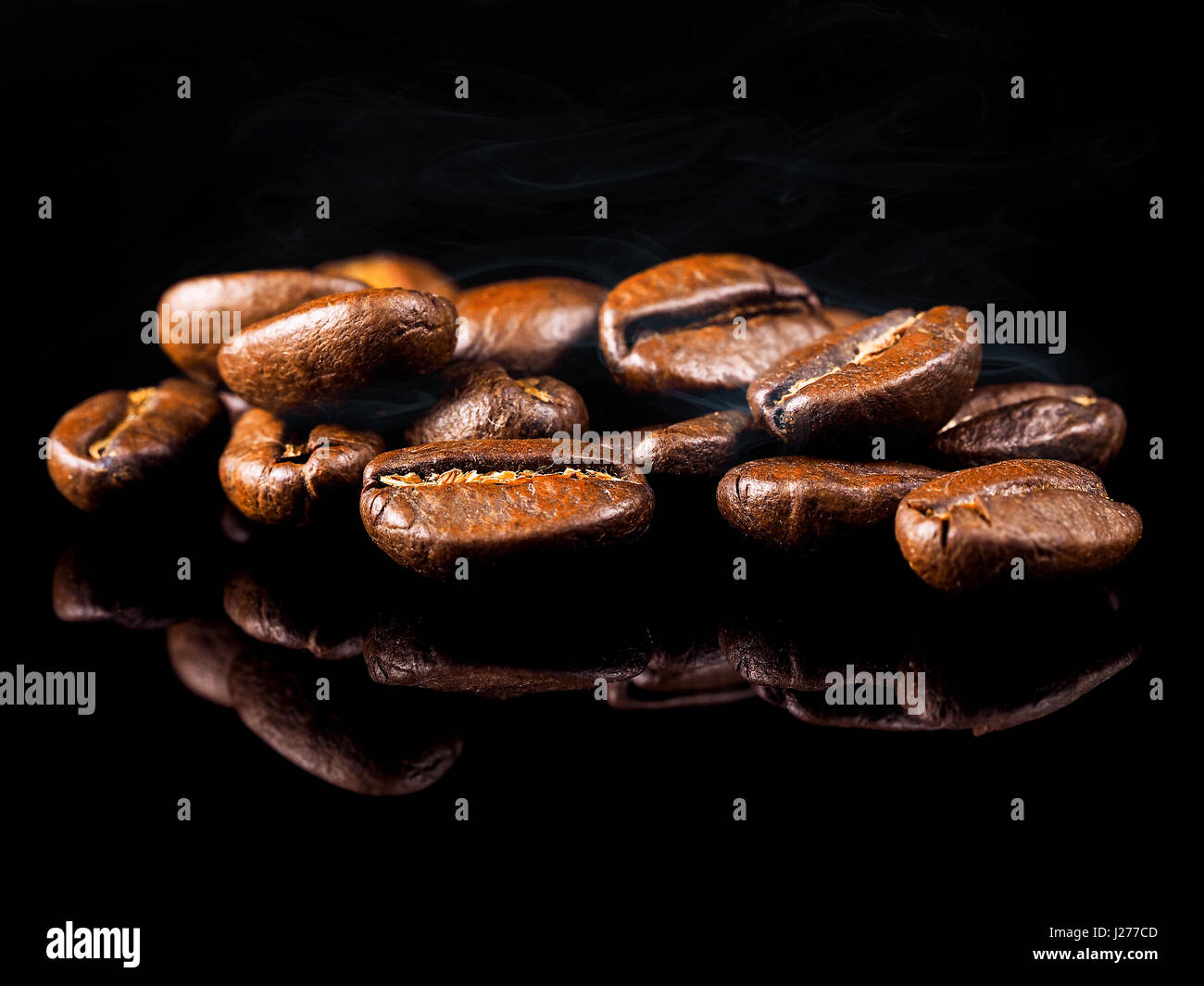 Roast coffee beans on the black background Stock Photo - Alamy