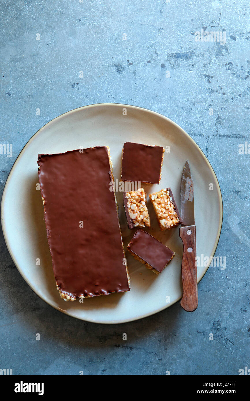 Puffed millet bars with peanut butter and dark chocolate on a plate.Top