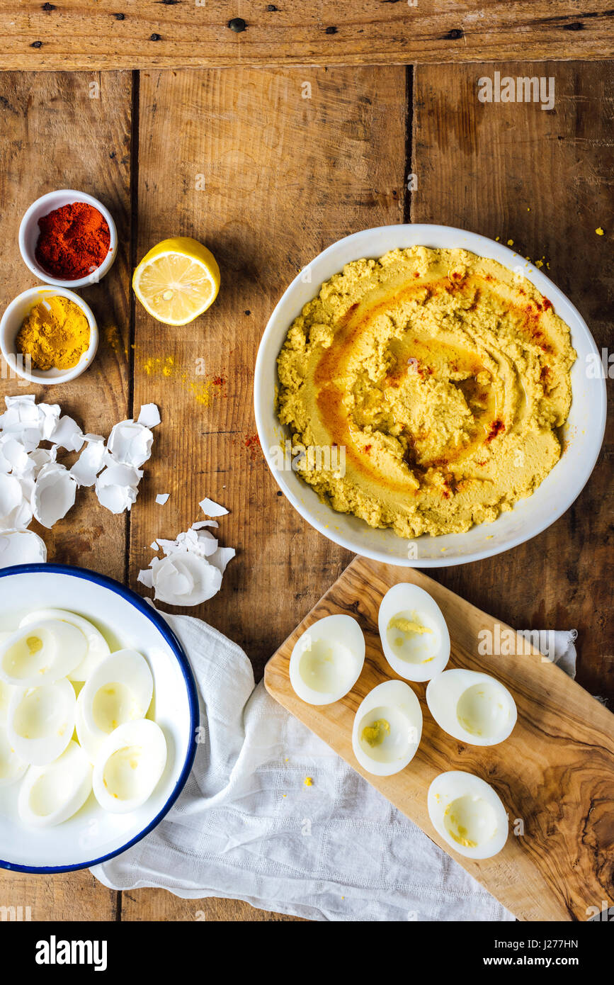 Hummus with hardboiled egg yolks in a bowl, egg whites in another bowl