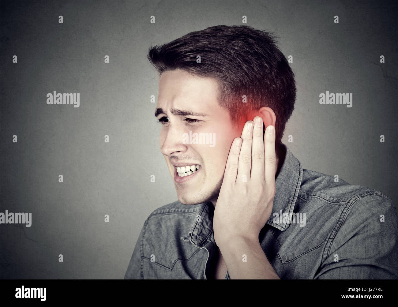 Tinnitus. Closeup up side profile sick male having ear pain touching his painful head isolated on gray background Stock Photo Alamy