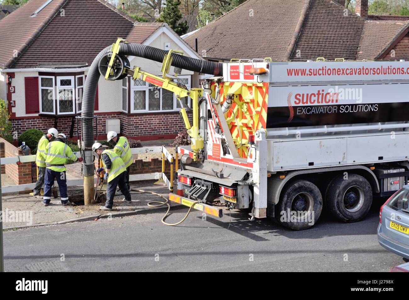 Large suction lorry excavating  a hole in a suburban pavement in Shepperton Surrey UK Stock Photo