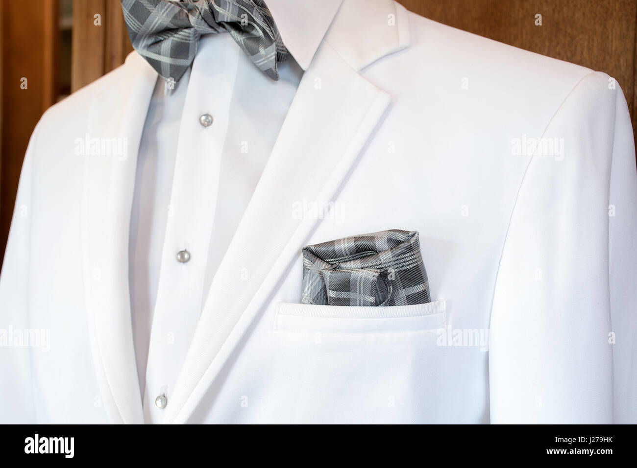 white tuxedo with silver gray plaid bow tie and handkerchief in pocket Stock Photo