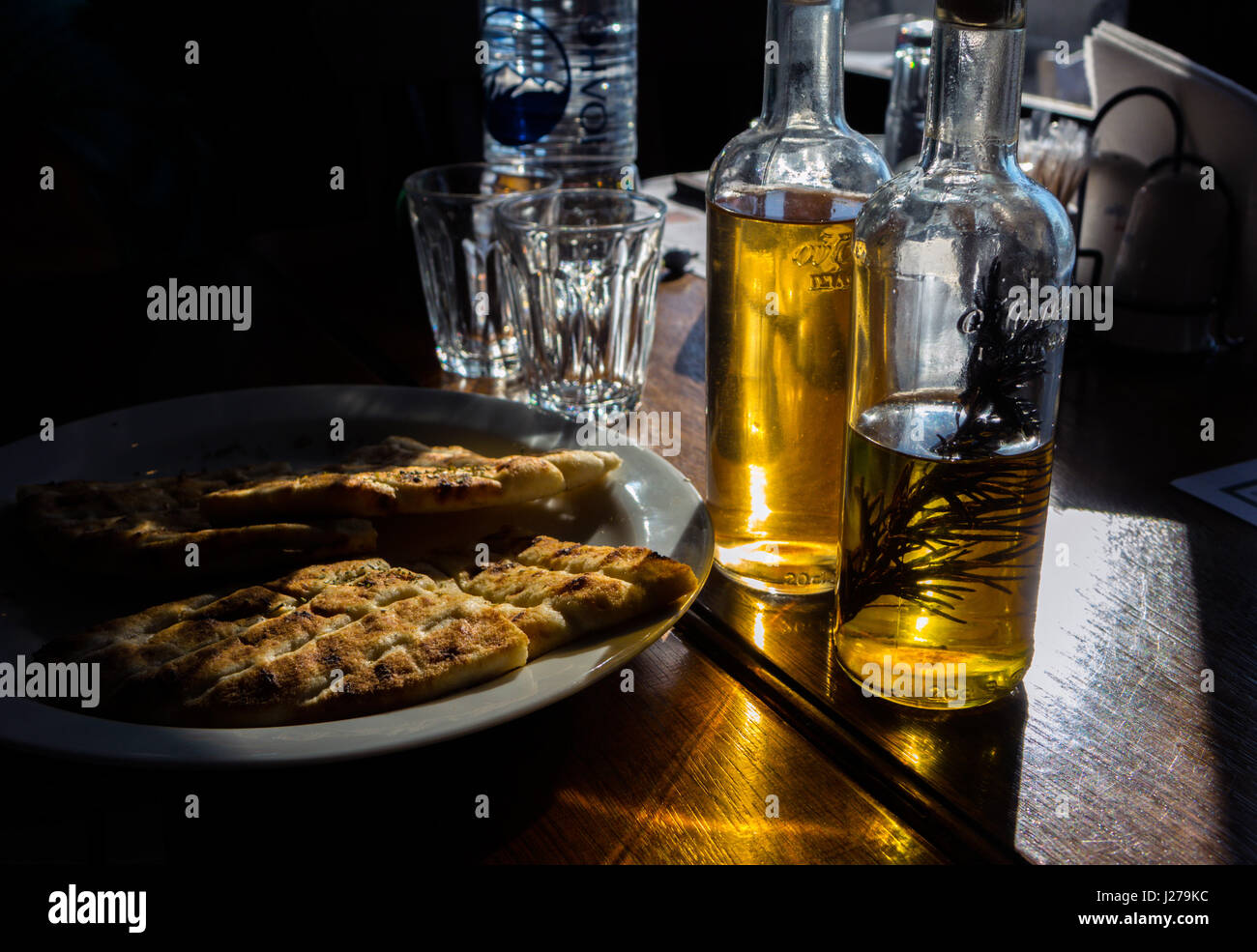 Olive oil and vinegar bottles on restaurant table in sunshine, Rhodes