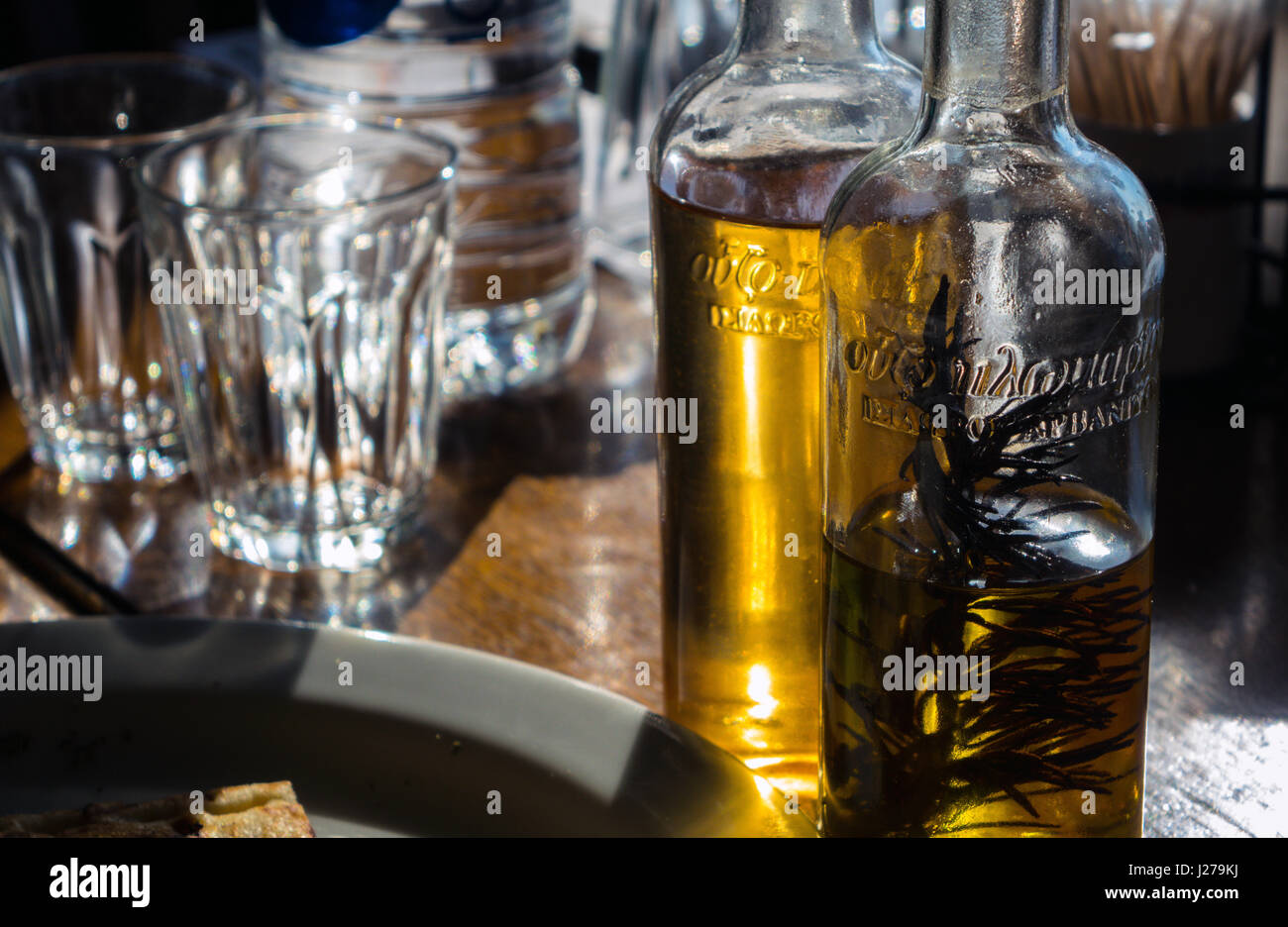 Olive oil and vinegar bottles on restaurant table in sunshine, Rhodes, Greece Stock Photo