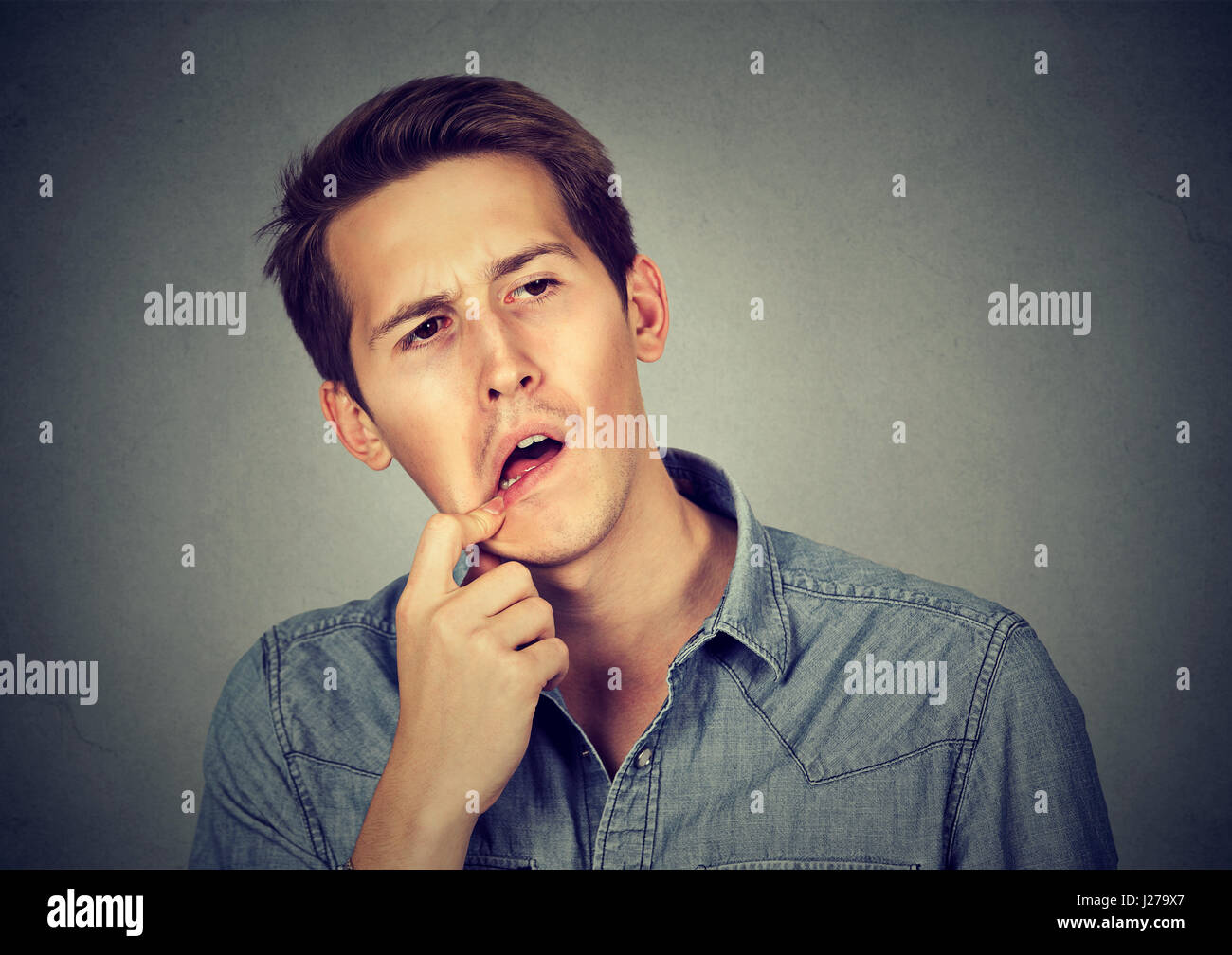 Confused perplexed man isolated on gray background Stock Photo