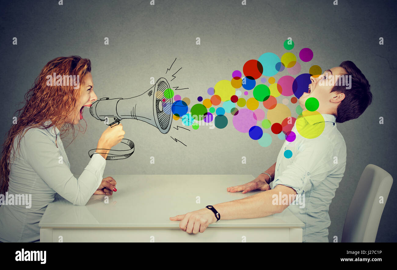 angry young woman shouting at stressed scared man Stock Photo