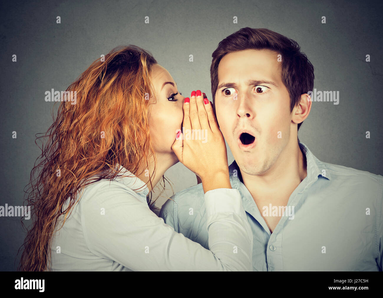 amazed shocked man listening gossip a secret in the ear Stock Photo