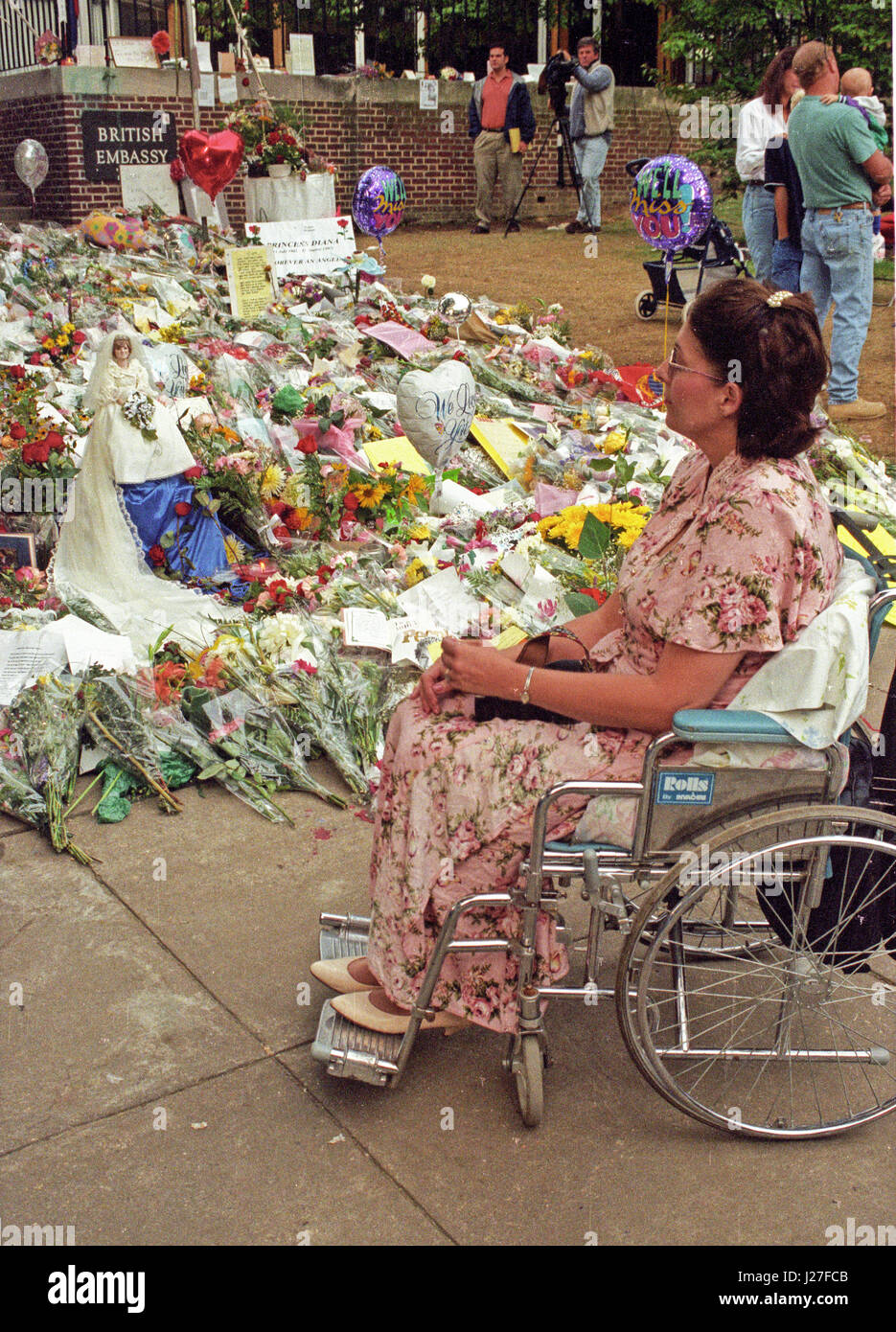 Danette Byrne of Hampstead, MD looks at the flowers and gifts left in tribute to the late Princess Diana while waiting for the British Embassy in Washington, DC to open to sign the Book of Condolence for Princess Diana on September 6, 1997. Danette owns the 'Princess Diana Bride Doll' seen at left and wanted to display it at the embassy in tribute to the late Princess. The Princess was killed in a car crash in Paris, France. Credit: Ron Sachs / CNP - NO WIRE SERVICE- Photo: Ron Sachs/Consolidated News Photos/Ron Sachs - CNP Stock Photo