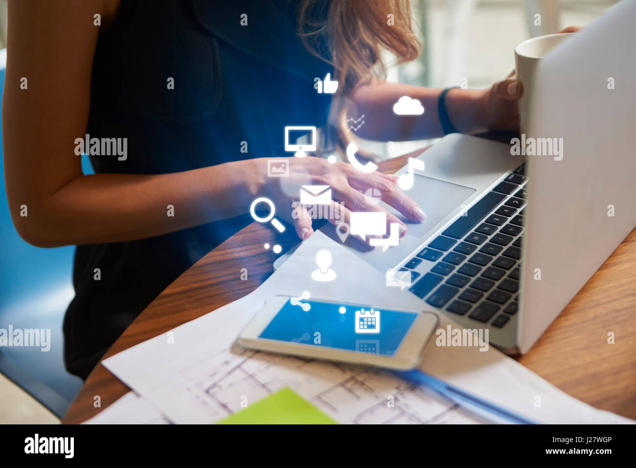 Businesswoman working an office with mobile app icons Stock Photo