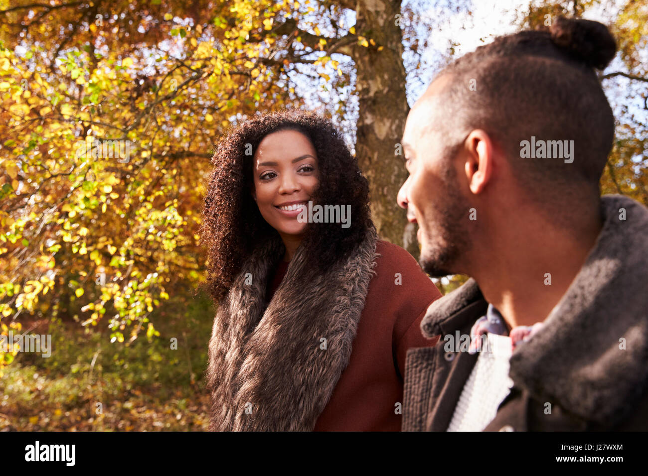 Young Couple Walking In Autumn Woodland Together Stock Photo