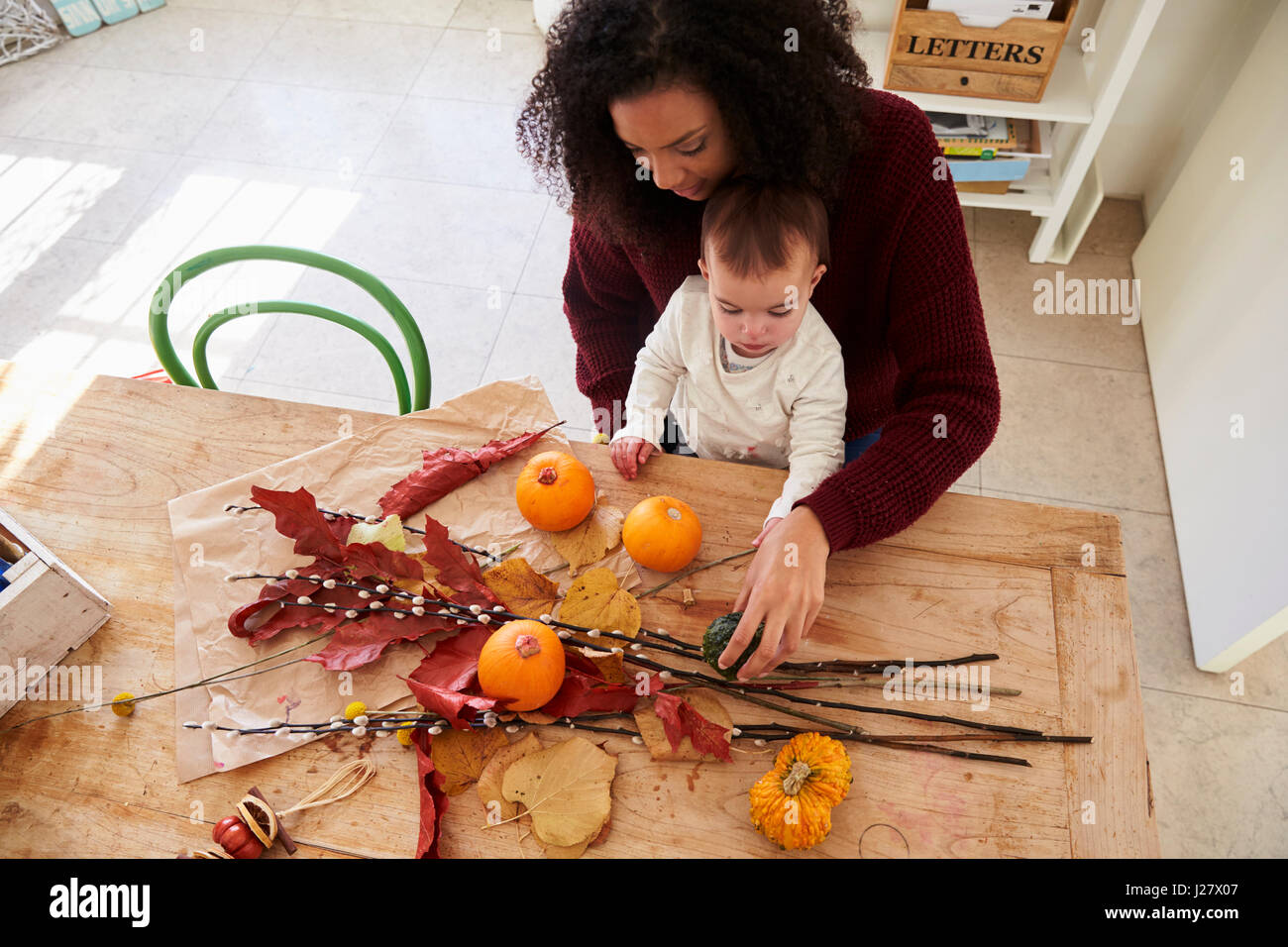 Mother And Daughter Making Autumn Decoration At Home Stock Photo