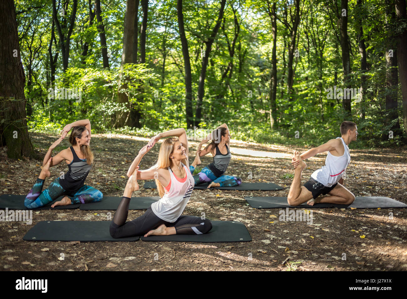 Fitness group practice relaxing anti-stress stretching in peace and harmony of nature Stock Photo