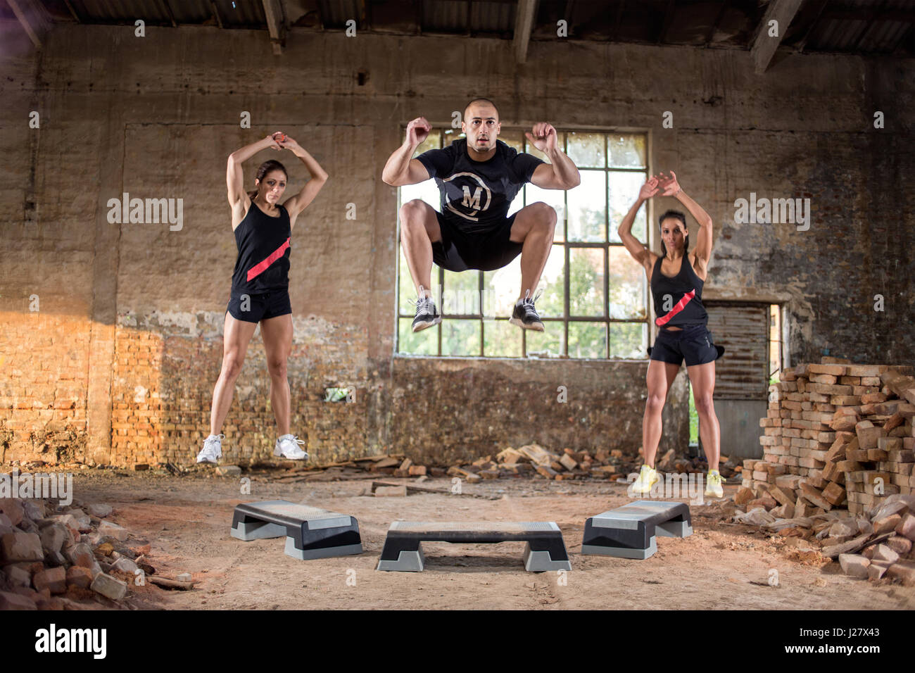 Young sport people jump off on their grit condition training in hangar Stock Photo
