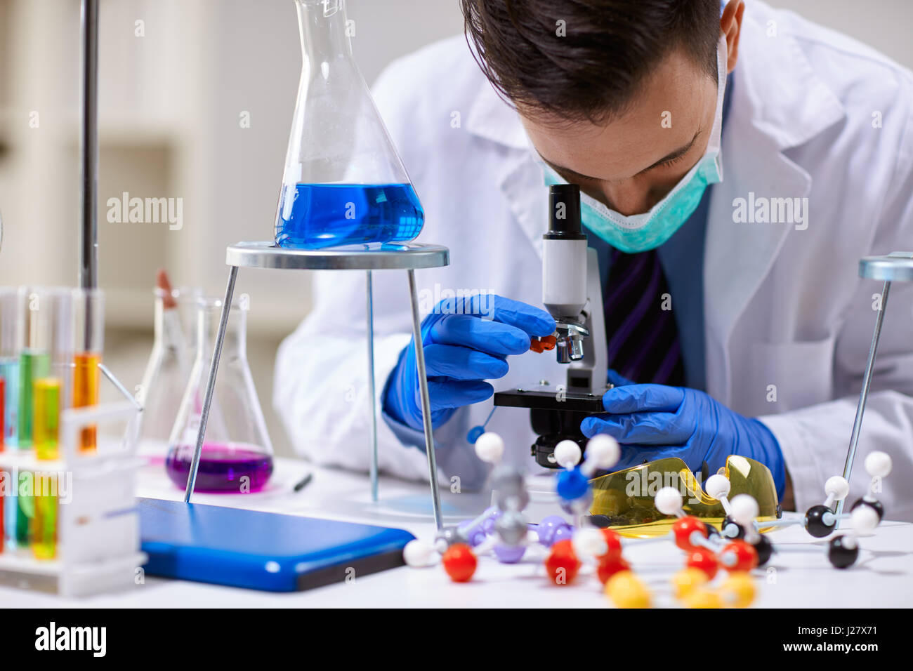 Scientist analyzing using a microscope   in a laboratory Stock Photo