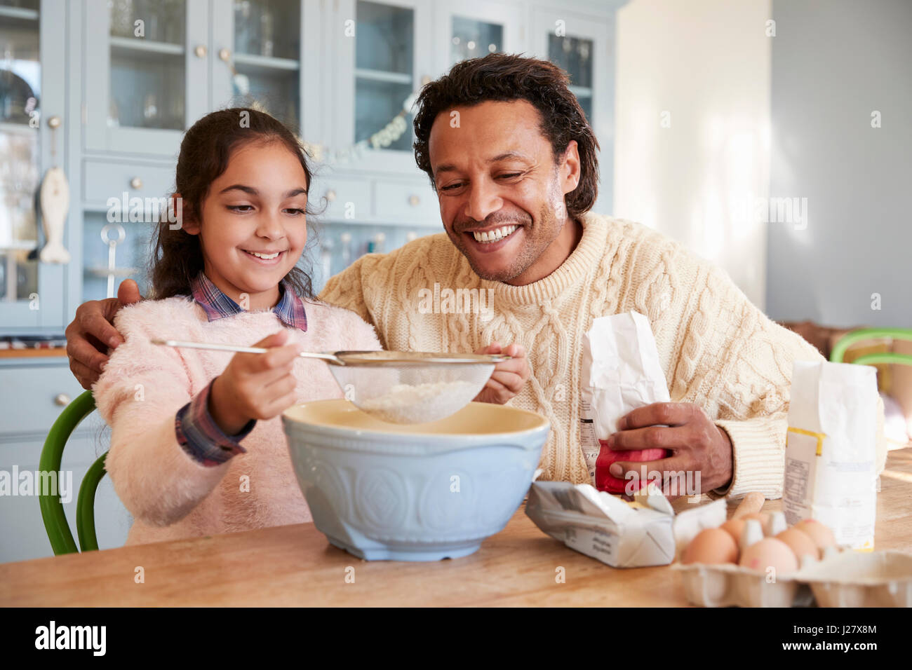 Father And Daughter Baking Cookies At Home Together Stock Photo