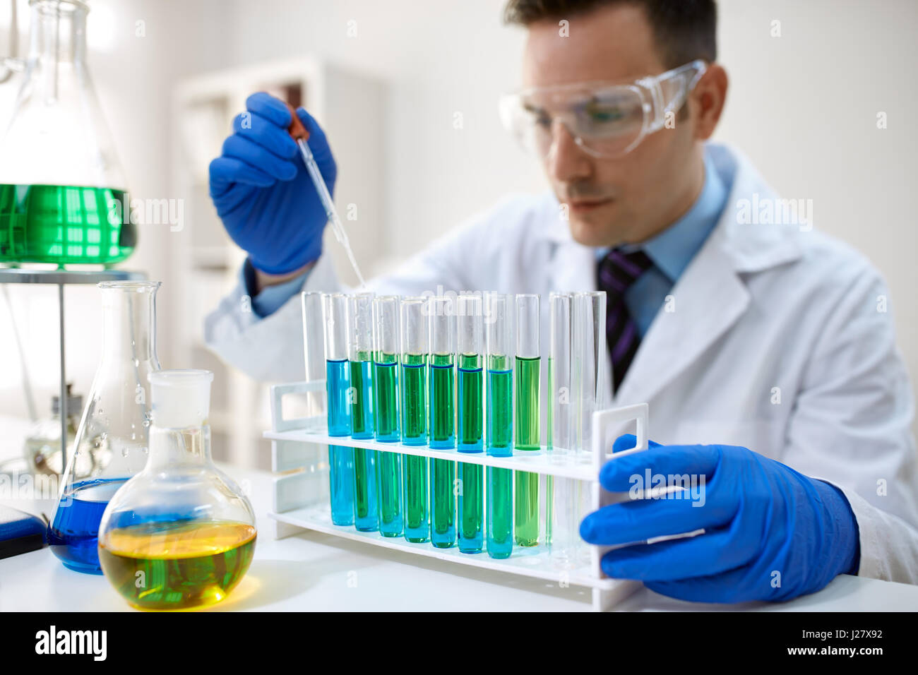 Male scientist using chemistry liquid for research in laboratory Stock Photo