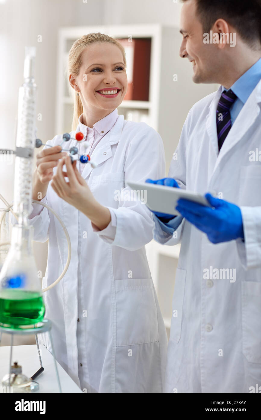 group of smiling scientist analyzing molecular structure in laboratory Stock Photo