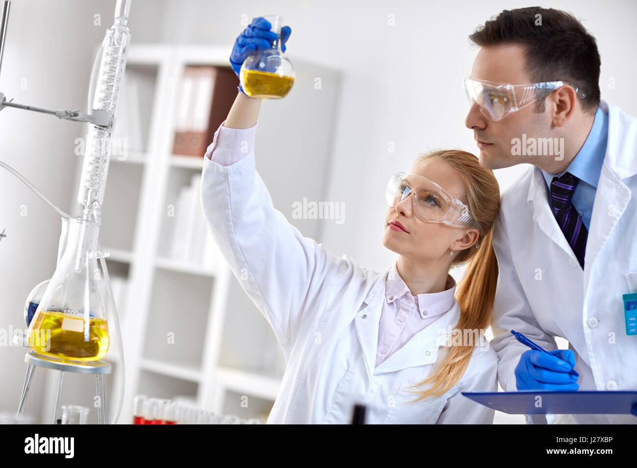Young chemical student researcher holding flask in laboratory Stock Photo