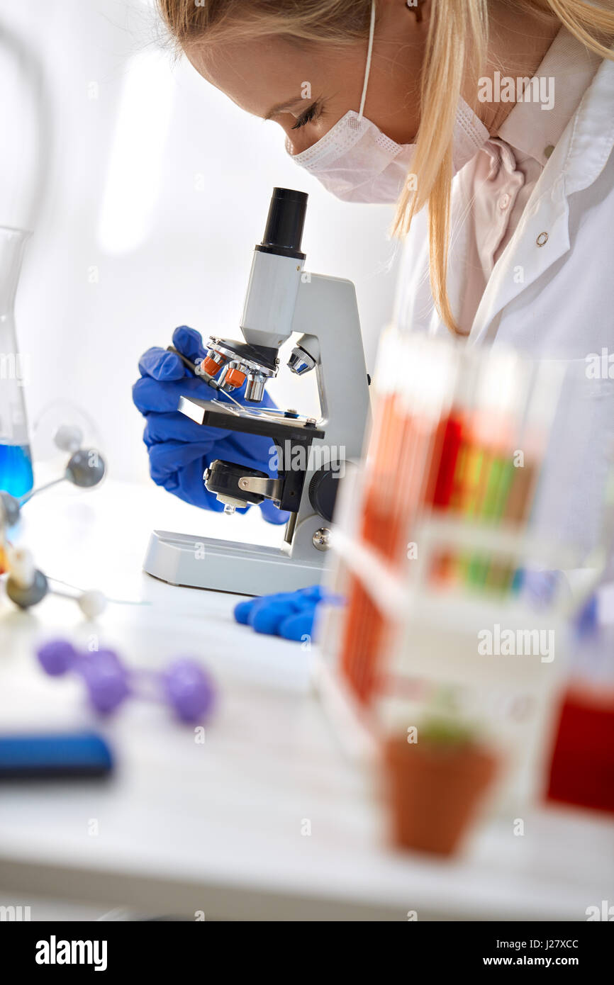 Scientist and microscope in laboratory Stock Photo