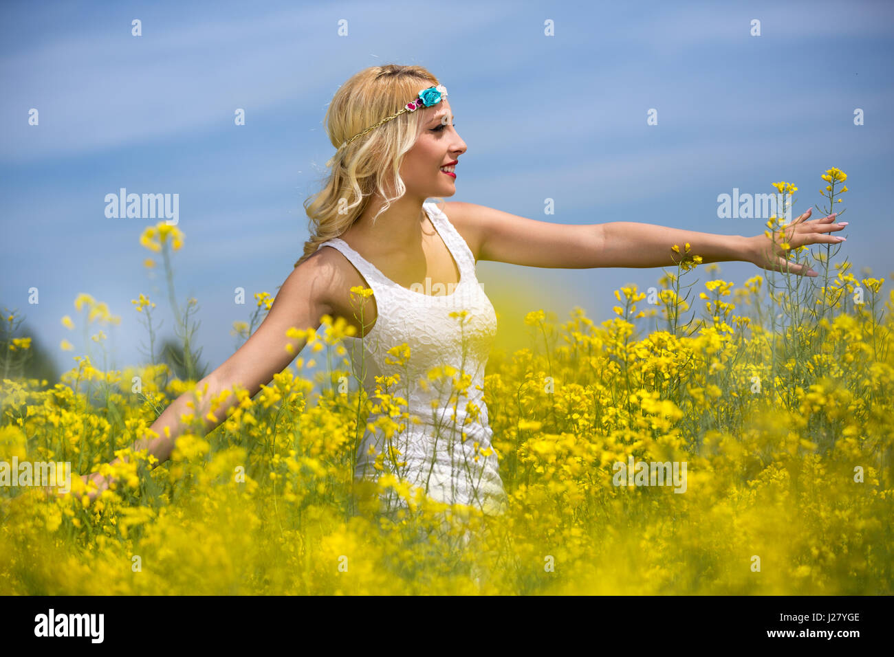 Healthy smiling girl in yellow field with flowers Stock Photo - Alamy