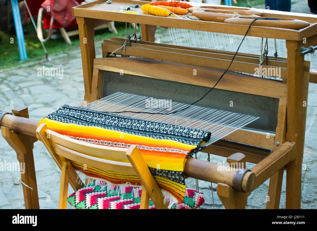 Hand loom with many colorful woolen threads Stock Photo