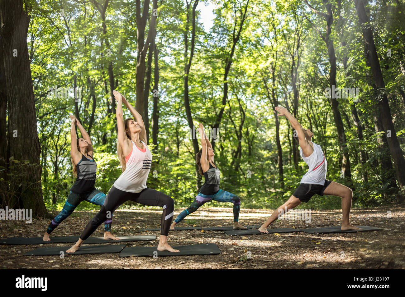 Young yoga and balance practitioners training in shiny forest Stock Photo