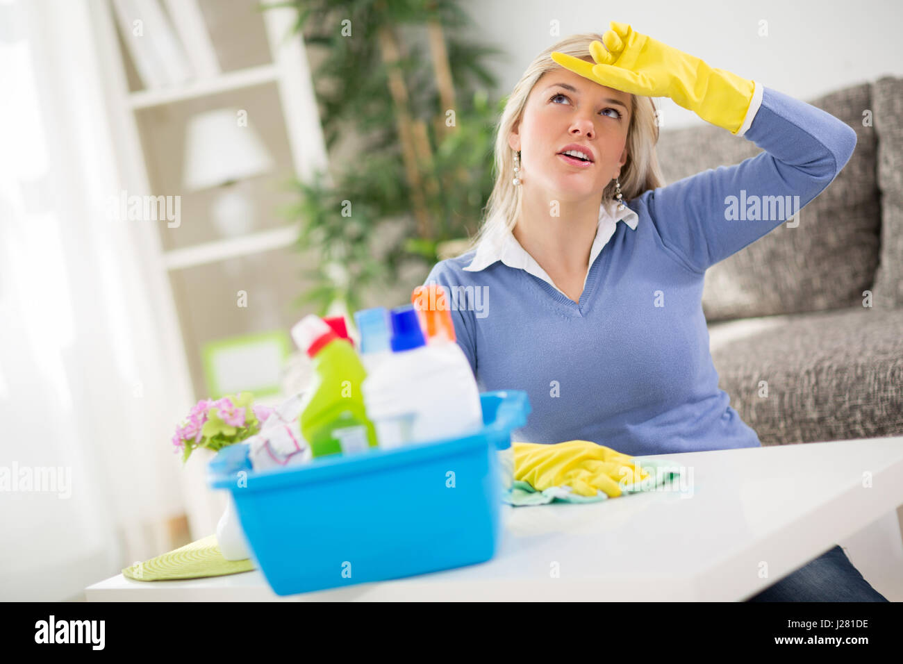 Young woman cleans table in room Stock Photo