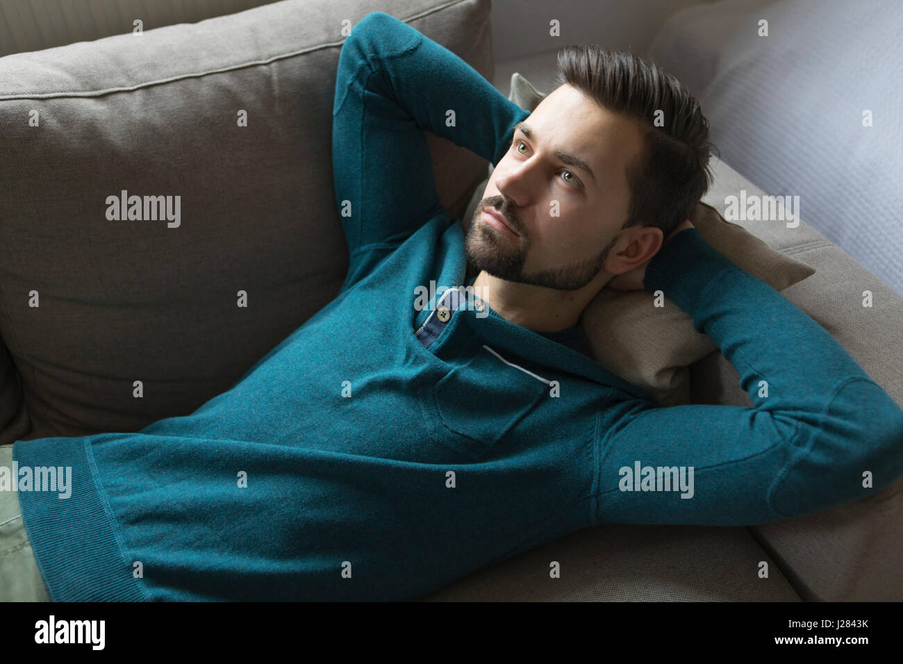 Man lying down on sofa hi-res stock photography and images - Alamy