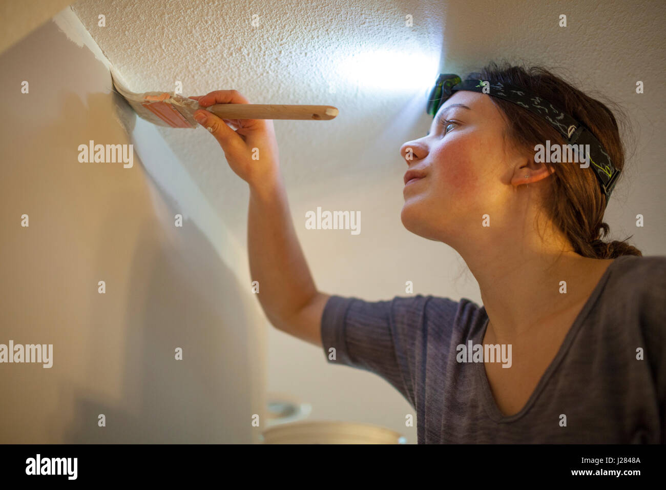 Low angle view of woman painting wall at home Stock Photo